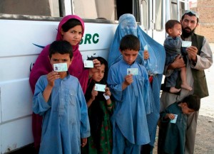 Afghan refugees hold up cards providing proof of registration, in Maach, Pakistan in 2008. A new pilot programme that began this week is issuing citizen cards to undocumented Afghans in Pakistan.   © UNHCR/DAKhan